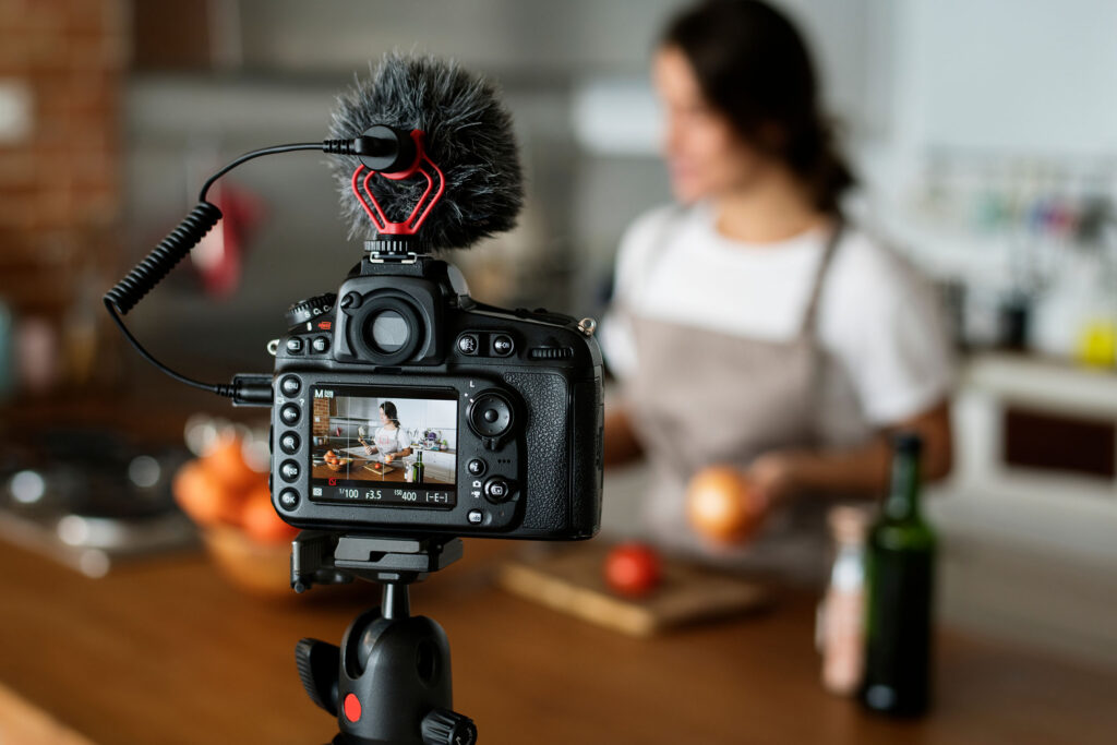 Female vlogger recording cooking related broadcast at home
